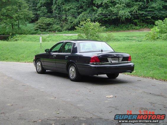 Dark sedan parked on asphalt, rear view. License plate reads 6294521