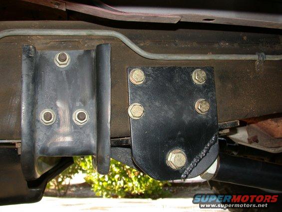 Close-up of aftermarket suspension brackets bolted to a vehicle frame