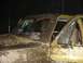 1989 Ford Bronco - This heavily muddied vehicle appears to be a truck, possibly an older model, with its driver's side door ajar.