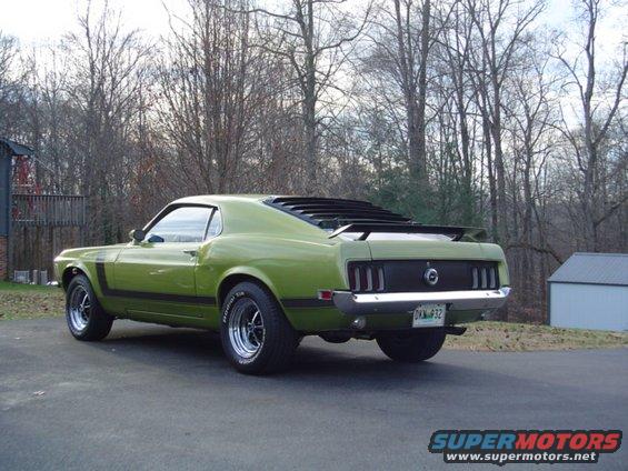 Green 1970 Ford Mustang with black stripe on side and louvers on rear window