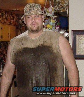 Man wearing a dirty, sleeveless shirt and a camouflage bucket hat indoors