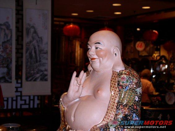 Buddha statue with ornate robe, right hand raised in a gesture