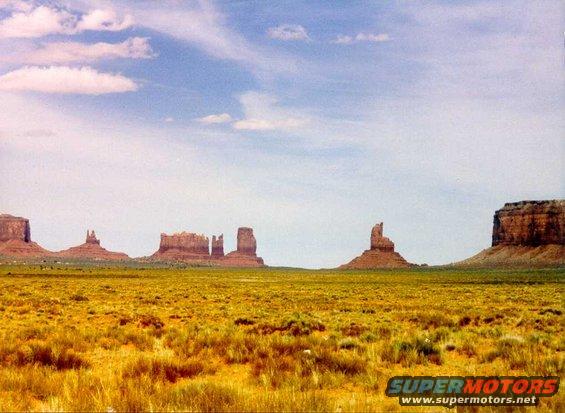 Monument Valley landscape with mesas and dry grass under a cloudy sky