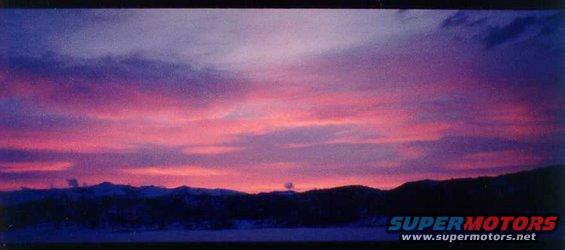 sunset with purple and pink clouds over dark mountains