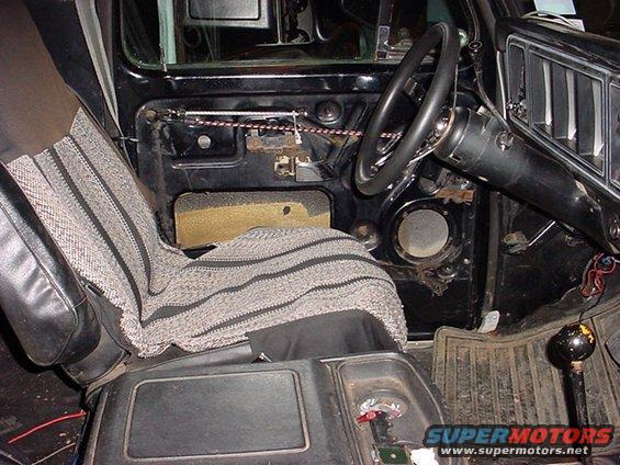 Interior of a 1978 Ford Bronco showing the driver's side door panel, seat, and dashboard