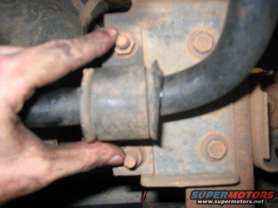 finger points to sway bar mount bolt on rusty bracket