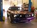 1978 Ford Mustang II - A 1978 Ford Mustang II with a custom paint job is parked in a garage, showing its front grille and headlights.