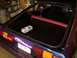 1978 Ford Mustang II - The interior of a purple 1978 Ford Mustang II hatchback, showing the trunk area with a small box and the rear seats.