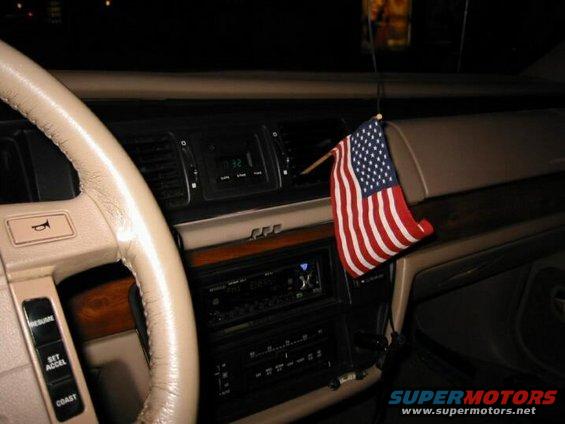 Interior dashboard with American flag hanging from vent. Clock shows 0:32