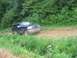 1988 Ford Bronco - Dark blue SUV on a dirt road, possibly stuck or being towed.