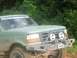 1988 Ford Bronco - Off-road Bronco with custom front end modifications and a website sticker on the windshield.