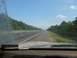 1988 Ford Bronco - Driving on a highway with trees on either side. A watermark indicates the image is from Supermotors.net.