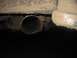 1988 Ford Bronco - Close-up view of a vehicle's exhaust pipe and the underside of its body, covered in dirt.