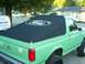 1990 Ford Bronco - This 1990 Ford Bronco features a black soft top with a prominent Ford logo on its rear.