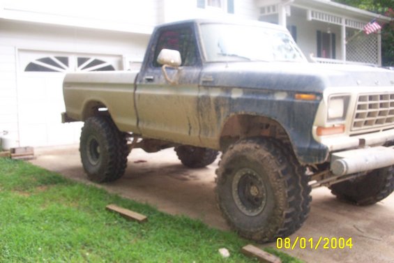 Lifted 1979 Ford F-150 with mud on its body, parked in a driveway