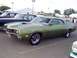 1999 Ford Taurus - This green coupe, likely from the 1970 model year, is parked alongside other vehicles.