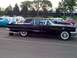 1999 Ford Taurus - A black 1960 Ford Thunderbird coupe is parked in a lot next to other vehicles.