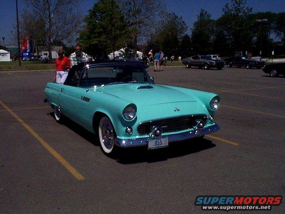 Turquoise 1955 Ford Thunderbird convertible with a black top, chrome accents, and whitewall tires