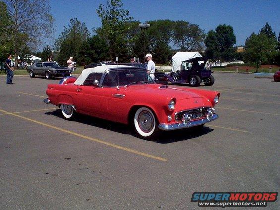 Red convertible classic car with white top, front 3/4 view