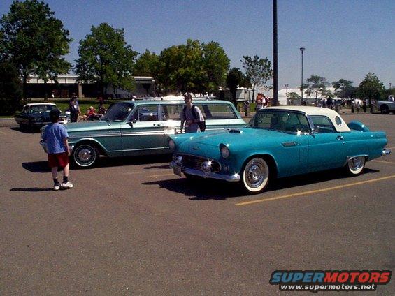 Turquoise 1955 Ford Thunderbird with white roof parked next to a teal station wagon