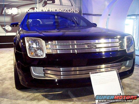 Dark blue Ford concept car with chrome grille and headlights, on display