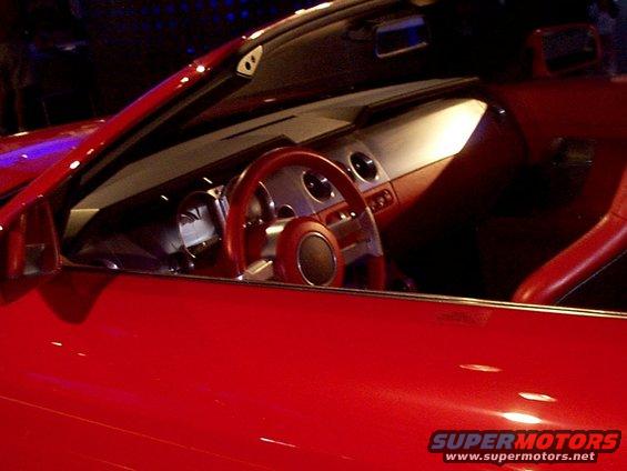 Red convertible interior with a red steering wheel and silver gauges