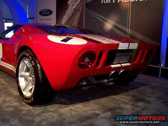 Red sports car with white racing stripes and a white circle with the number 7 on the rear quarter panel