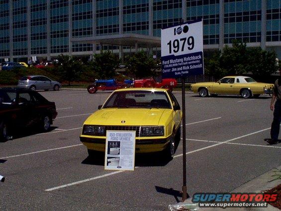 Yellow 1979 Ford Mustang Hatchback with a sign indicating it is the 150-millionth Ford vehicle