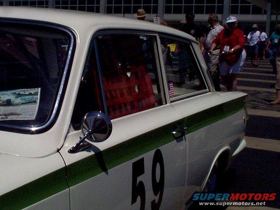 White sedan with green stripe and number 59, side view, chrome mirror, red interior visible