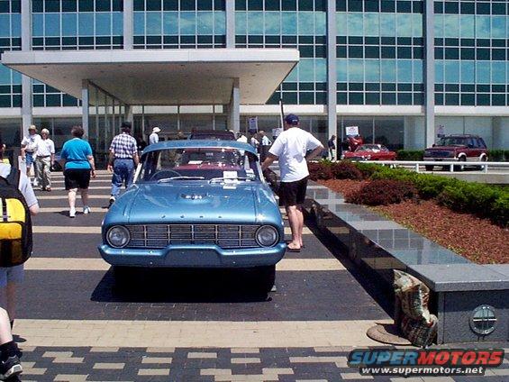 Blue sedan with chrome grille and round headlights, parked on patterned pavement