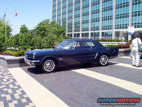 Dark blue 1965 Ford Mustang coupe parked on brick pavement