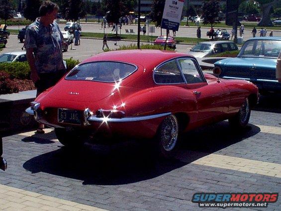 Red 1963 Jaguar E-Type coupe with wire wheels and a "63 JAG" license plate