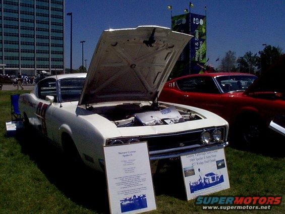 White 1969 Dodge Charger with hood open, red car behind it
