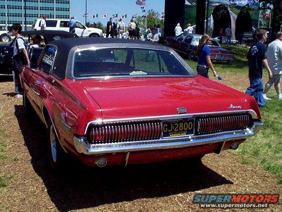 Red coupe with a black vinyl roof and a GJ-2800 license plate, viewed from the rear