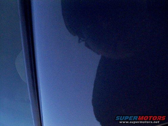 Close-up of a dark blue car door with reflections
