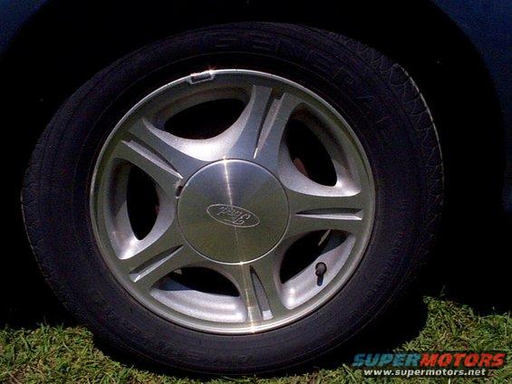 Close-up of a 1999 Ford Taurus SE wheel with a Ford logo on the hubcap