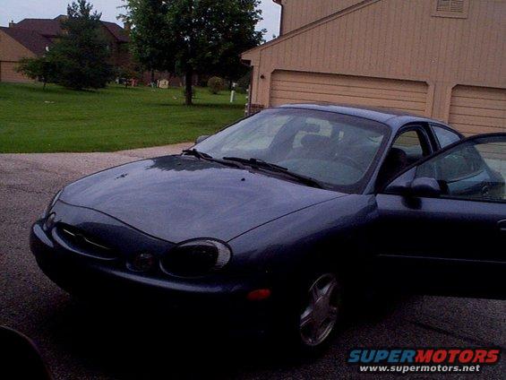 1999 Ford Taurus SE sedan with driver's door open, parked in driveway