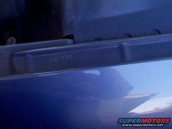 stamped numbers 03 7M2 on blue car part