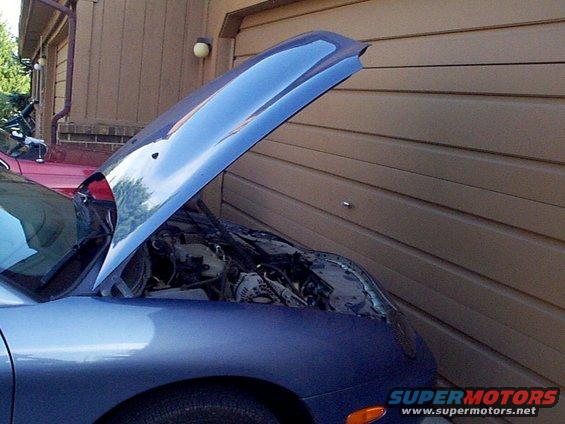 Blue car with hood open, revealing engine bay. Red car visible behind it