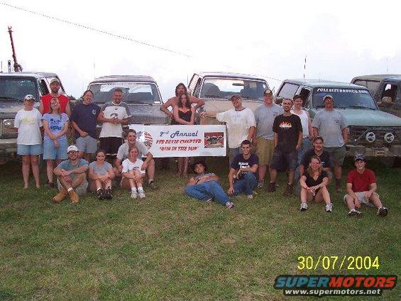 group of people posing in front of several trucks, one has a banner that says '9th Annual Red Dixie Chapter "Run In The Sun"'