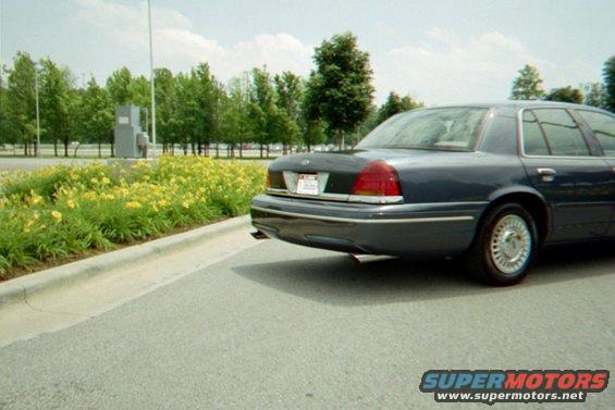 Dark blue sedan rear view, showing taillights and dual exhaust
