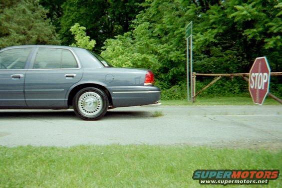 Gray Ford Crown Victoria parked next to a stop sign