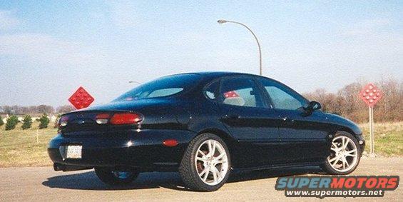 Black 1999 Ford Taurus sedan, rear 3/4 view