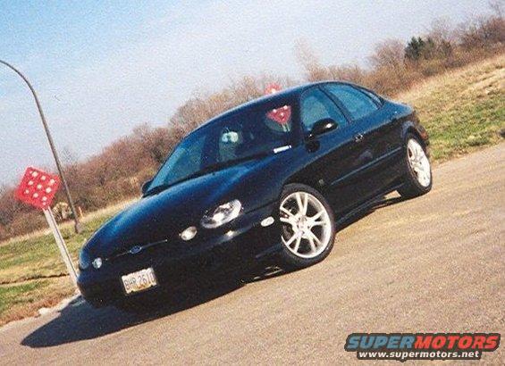 1999 Ford Taurus sedan parked on a road with a red and white signpost