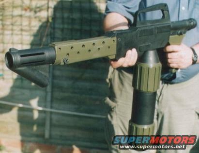 Prop gun with green and black parts, held by a person