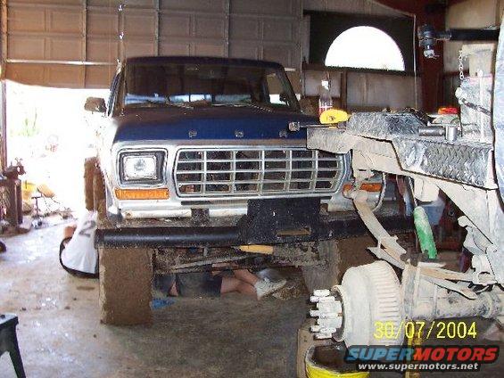 Blue Ford F-Series truck with a silver grille, being worked on in a garage