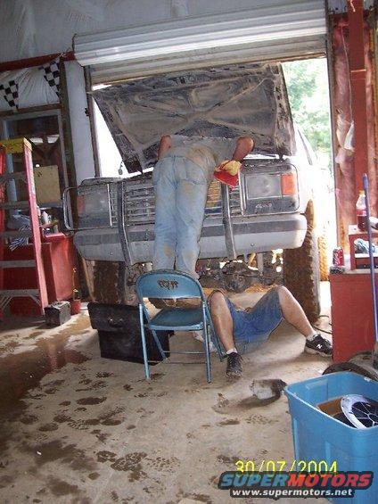Men working on dirty vehicle front view