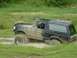 1995 Ford Bronco - This vehicle is navigating a challenging muddy terrain, with water splashing around its tires.