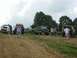 1995 Ford Bronco - Several off-road vehicles are gathered on a grassy hill under a cloudy sky.