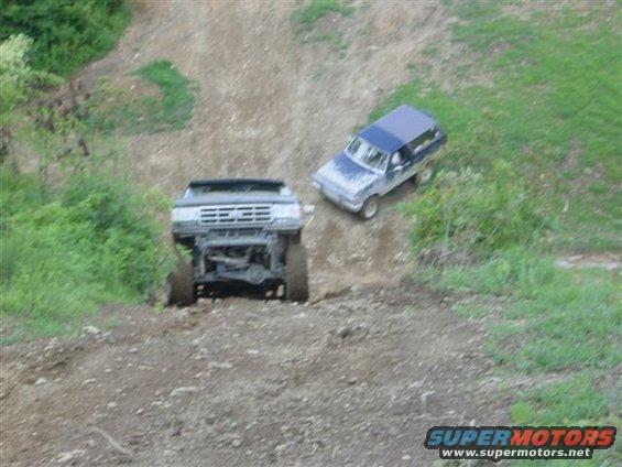 1995 Ford Bronco and blue SUV off-roading on a dirt hill